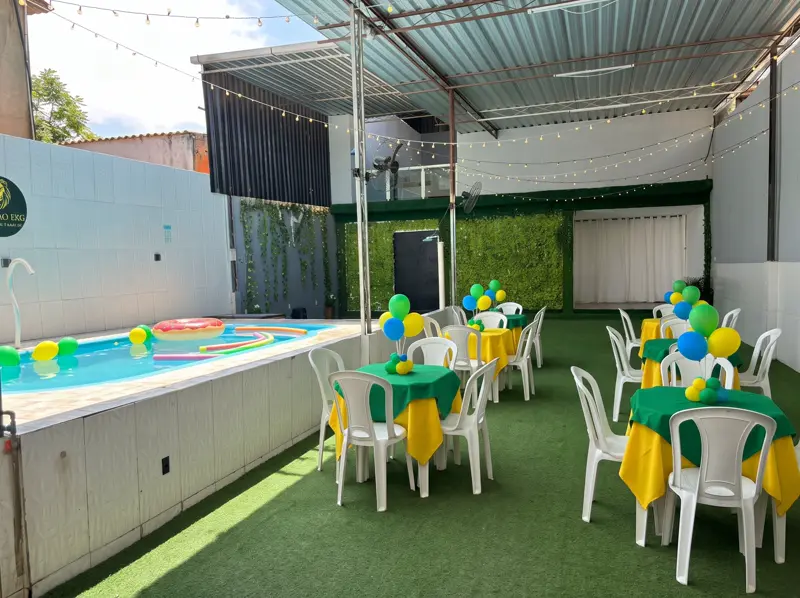 Mesas decoradas no gramado ao lado da piscina