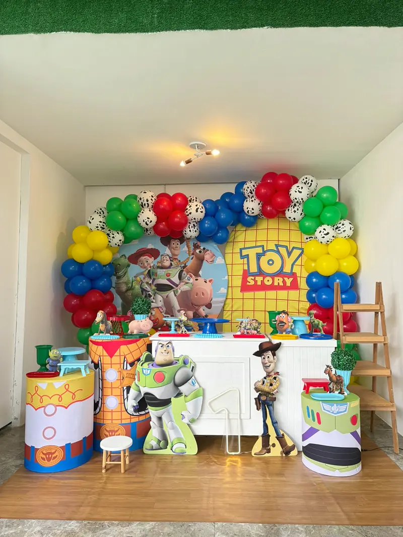 Mesa de aniversário com tema Toy Story e arco de balões coloridos